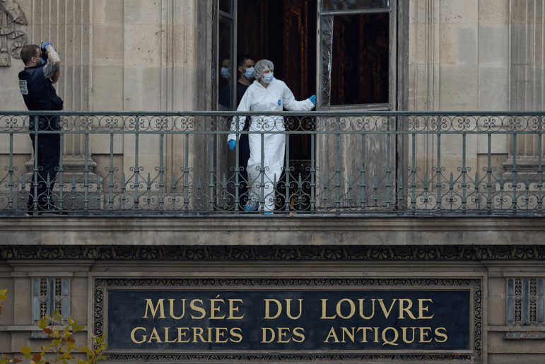 A forensics officer examines the cut window and balcony of a gallery at the Louvre Museum which was the scene of a robbery on October 19 in Paris.