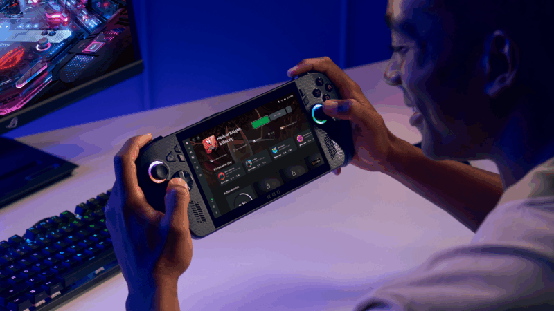 A promotional image for the ROG Xbox Ally X, demonstrating the handheld PC with a full gaming desktop nearby.