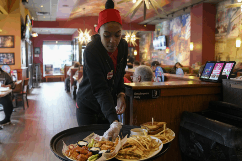 A server delivers food to a table at the world's largest Applebee's in New York City's Times Square.