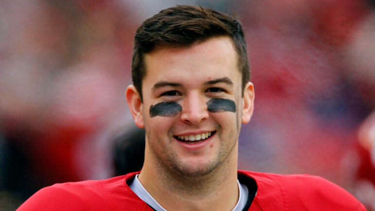 Alabama quarterback AJ McCarron smiles on sideline during an NCAA college football game.