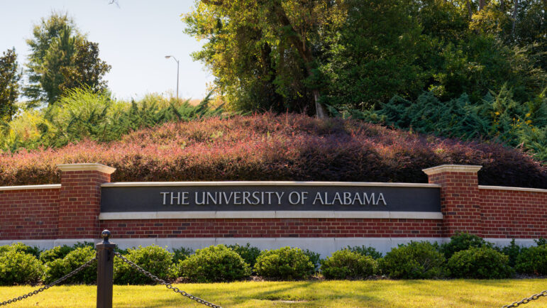 The University of Alabama sign in Tuscaloosa, Alabama on a brick wall with beautiful landscaping
