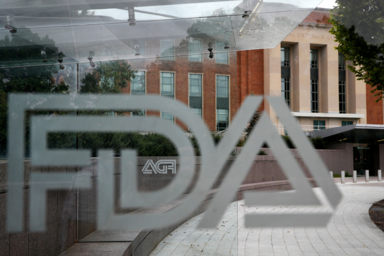 The U.S. Food and Drug Administration building is seen behind FDA logos at a bus stop on the agency's campus in Silver Spring, Md., Aug. 2, 2018.