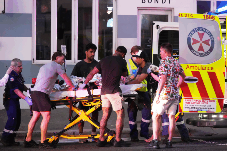 Emergency workers transport a person on a stretcher after a reported shooting at Bondi Beach in Sydney, Sunday, Dec. 14, 2025.