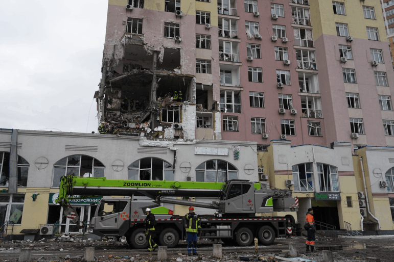 Rescuers work on the scene of a building damaged by a Russian attack in Kyiv, Ukraine, Saturday, Dec. 27, 2025.