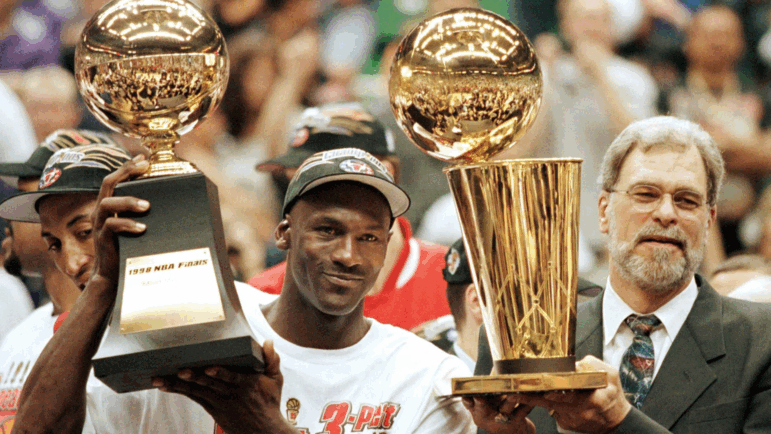 Michael Jordan and Chicago Bulls head coach Phil Jackson celebrate the team's sixth NBA championship on June 14, 1998.
