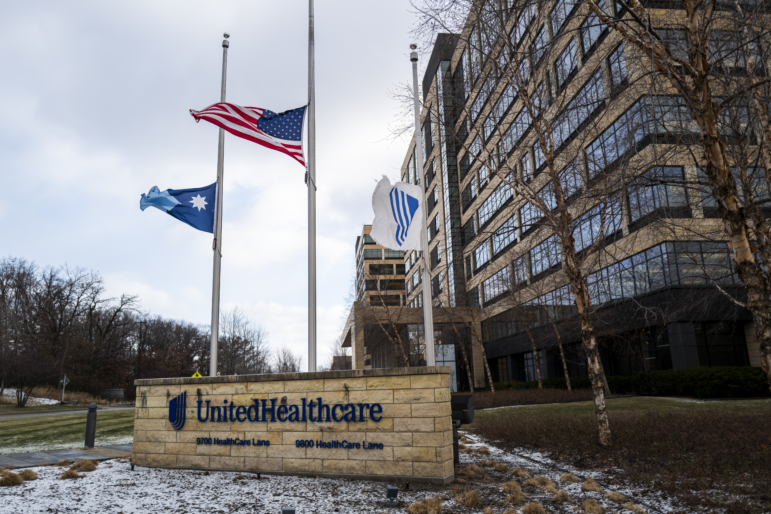 Flags fly at half-staff outside the UnitedHealthcare corporate headquarters on Dec. 4, 2024. There are patches of snow on the ground..