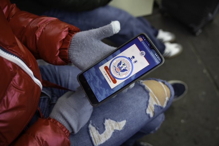 A immigrant from Venezuela tries in vain to access the CBP One app a day after the second inauguration of President Trump on January 21, 2025 in Nogales, Mexico. The incoming administration shut down the app, which was created by the Biden administration to allow migrants to schedule appointments to gain entry into the United States.