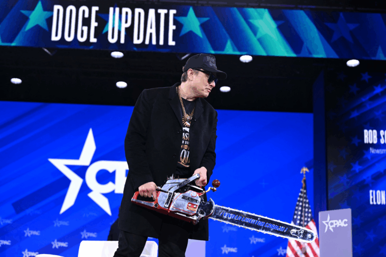 Elon Musk holds a chainsaw reading "Long live freedom, damn it" during the annual Conservative Political Action Conference (CPAC) at the Gaylord National Resort & Convention Center at National Harbor in Oxon Hill, Maryland, on February 20, 2025. The chainsaw was a present to Elon Musk from Argentina's President Javier Milei.