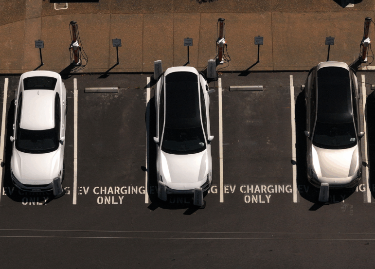 Electric cars sit parked at a charging station in Corte Madera, Calif., in May 2025.