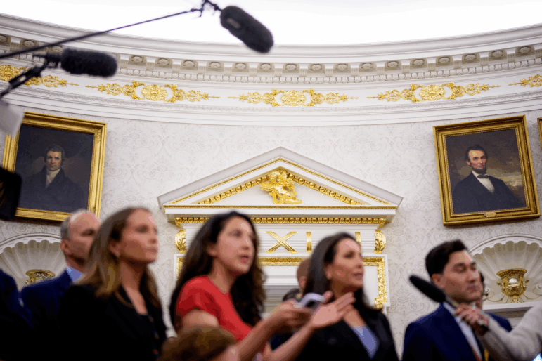 Paintings and gold trim are visible behind reporters as U.S. President Donald Trump holds a swearing in ceremony.
