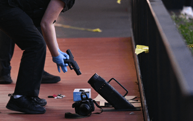 A law enforcement officer inspects a handgun at the scene of a shooting in Washington, D.C., on Oct. 2, 2025.