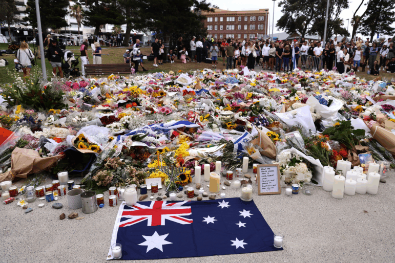 Mourners gather around floral tributes at Bondi Pavilion on Tuesday to honor the victims of the Bondi Beach shooting in Sydney on Tuesday.
