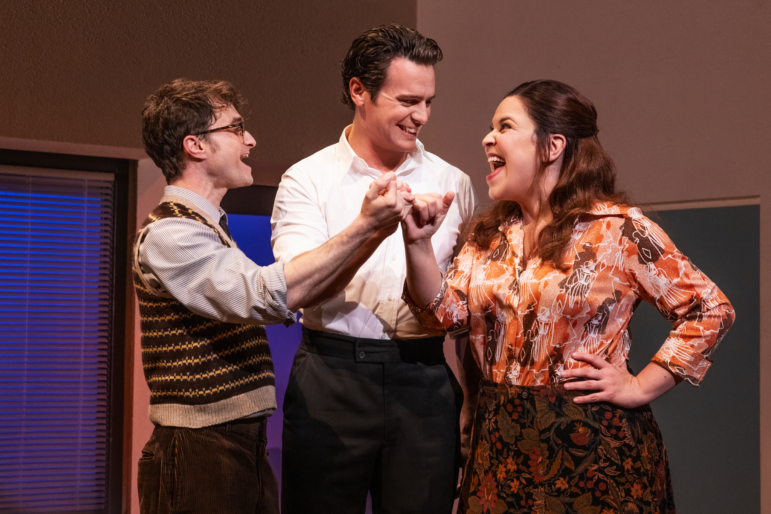 Daniel Radcliffe as Charley Kringas, Jonathan Groff as Franklin Shepard and Lindsay Mendez as Mary Flynn in Merrily We Roll Along, the Stephen Sondheim musical filmed on Broadway and now in theaters.