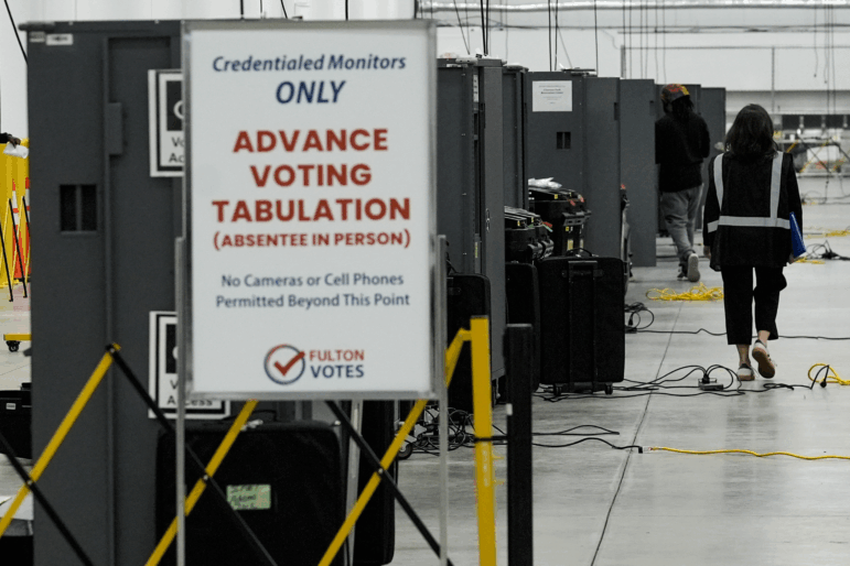 An election worker walks near voting machines at the Fulton County Election Hub and Operation Center on Nov. 5, 2024.