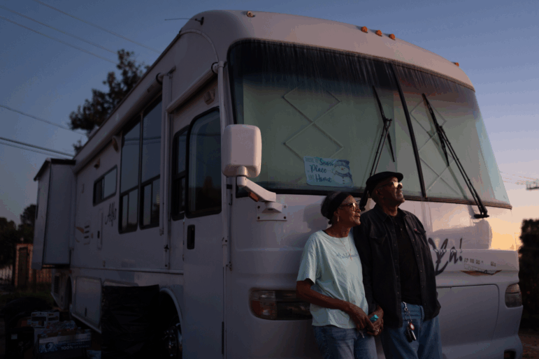 Ellaird Bailey and his wife, Charlotte, who lost their home in Altadena, California, to a wildfire in early 2025, stand in front of their recreational vehicle in December 2025.