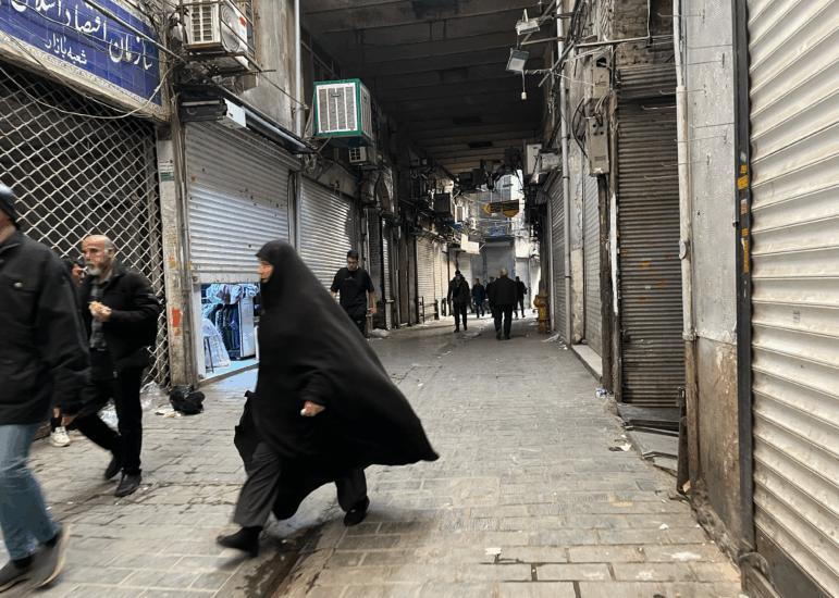 People walk as shops are closed during protests in Tehran's centuries-old main bazaar, Iran, Tuesday, Jan. 6, 2026.
