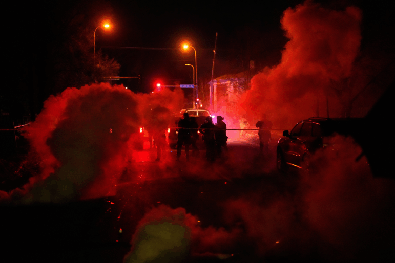Tear gas surrounds federal law enforcement officers as they leave a scene after a shooting on Wednesday, Jan. 14, 2026, in Minneapolis.