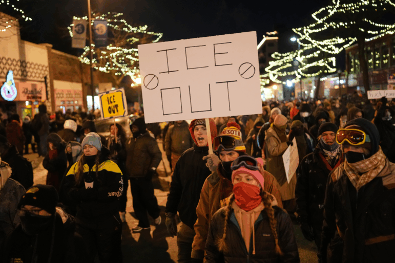 A person holds a sign during a vigil for 37-year-old Alex Pretti, who was fatally shot by a U.S. Border Patrol officer earlier in the day, Saturday, Jan. 24, 2026, in Minneapolis. (AP Photo/Adam Gray)