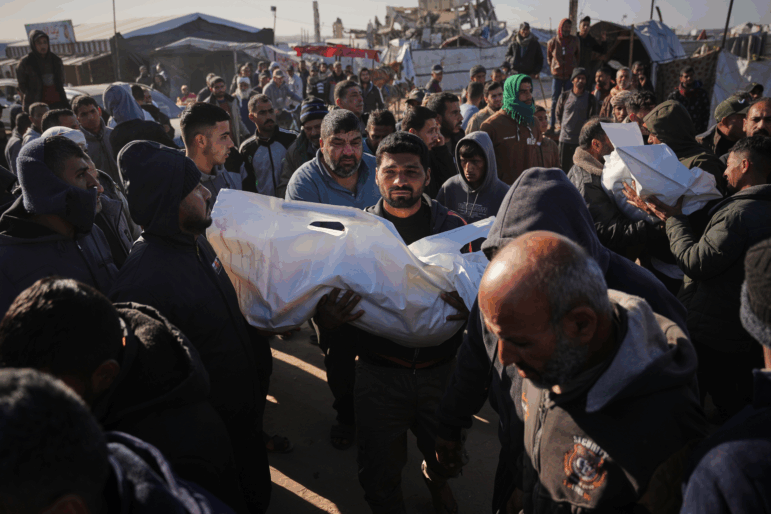 A Palestinian man carries the body of Sham Abu Hadaiyd, who was killed in an Israeli strike on a tent in Khan Younis, Gaza Strip, Saturday, Jan. 31, 2026.