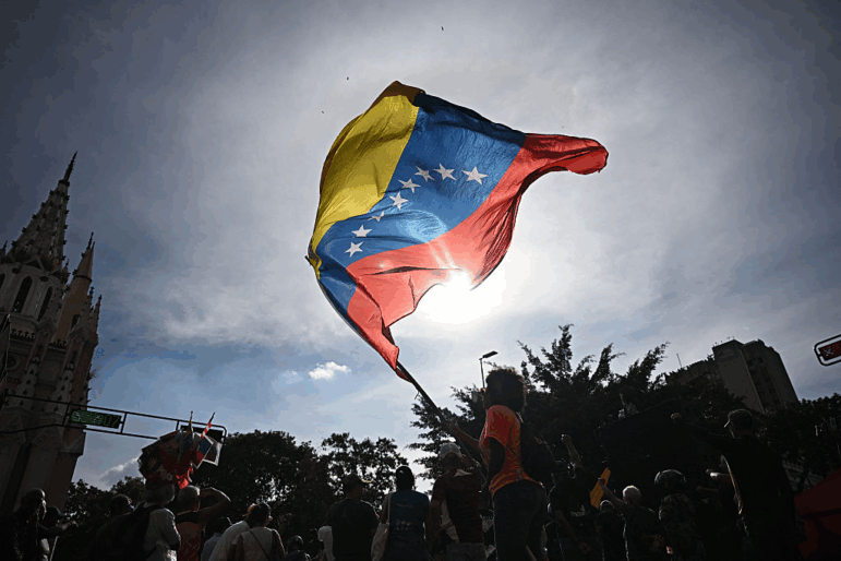A person flutters a national flag in Caracas on January 3, 2026, after US forces captured Venezuelan leader Nicolas Maduro.
