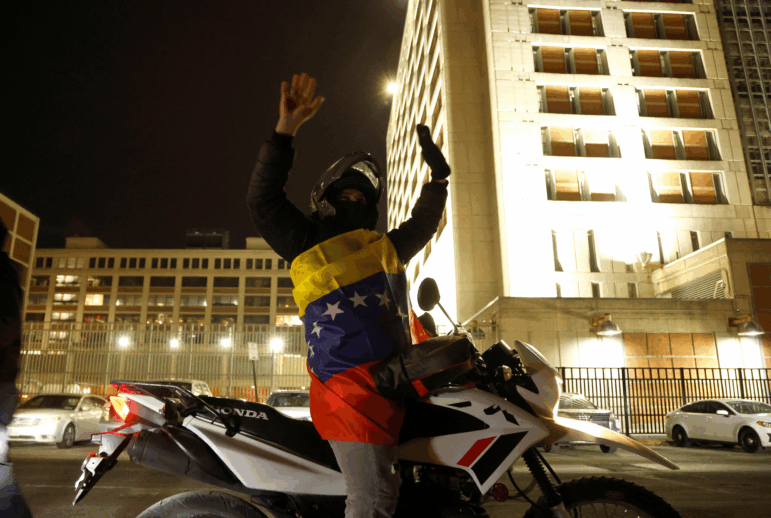 A Venezuelan supporter of U.S. operations in Venezuela celebrates in front of the Metropolitan Detention Center.