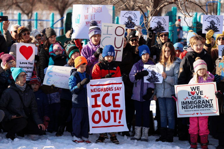 People observe a moment of silence in Minneapolis, Minn., at a news conference organized by the group Minneapolis Families for Public Schools.