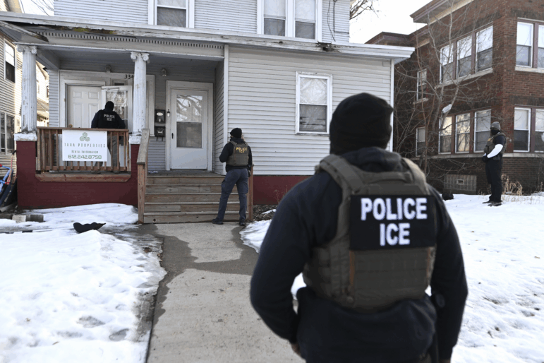 ICE agents approach a house before detaining two people on Jan. 13 in Minneapolis.