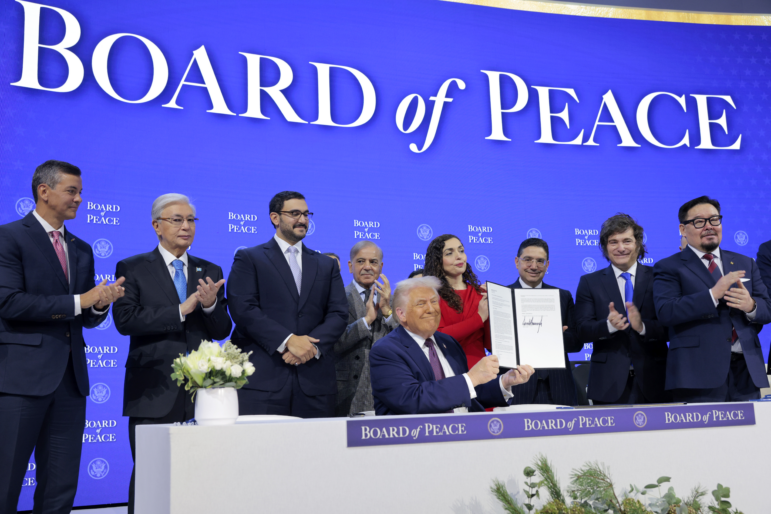 President Trump holds up his signature on the founding charter during a signing ceremony for the Board of Peace at the World Economic Forum on Thursday in Davos, Switzerland. The final makeup of the board has not been confirmed. (Photo by Chip Somodevilla/Getty Images)