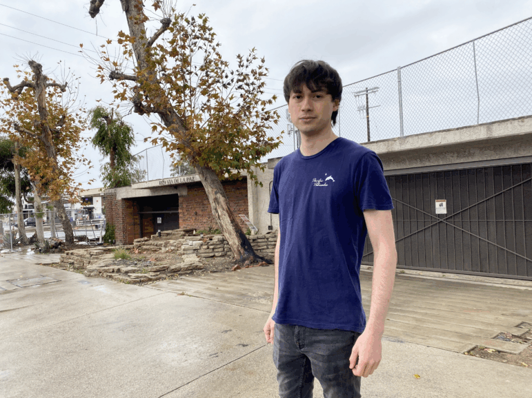 Chad Comey stands outside what's left of the five-story condo where he and his parents lived. The condo burned in the Palisades Fire.
