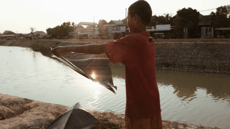 A boy does laundry near the Siem Reap River.