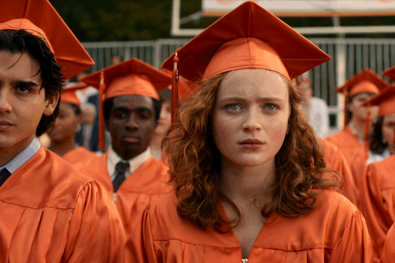 Sadie Sink as Max Mayfield in her graduation cap.