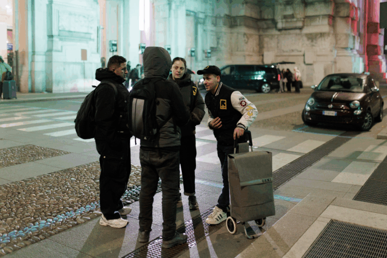 Members of an International Rescue Committee (IRC) outreach team patrol the main hall of Milano Centrale railway station during the night.