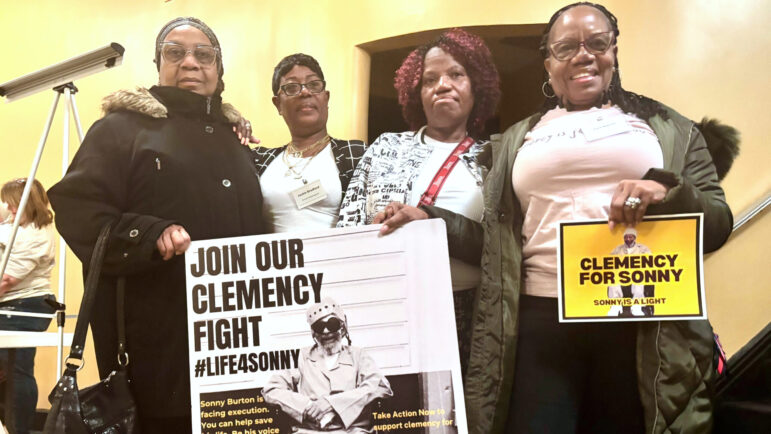 Eddie Mae Ellison, Jackie Bradford, Mary Bradford and Lois Harris hold signs urging Alabama Governor Kay Ivey to grant clemency for their family member Charles “Sonny” Burton.