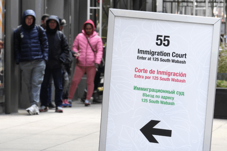 People wait in a line before being led into a downtown Chicago building where an immigration court presides on Nov. 12, 2024, in Chicago. (AP Photo/Charles Rex Arbogast)