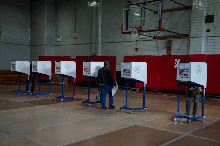 A voter carries a ballot during early voting for New York City's mayoral election on Oct. 25, 2025.