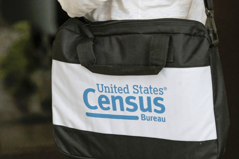 The U.S. Census Bureau’s logo is featured on a black bag carried by a census worker knocking on doors in 2020 in Winter Park, Fla.
