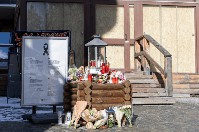 Flower tributes are placed at the entrance of the "Le Constellation" bar and lounge where a fire which broke out during New Year's celebrations left 40 people dead and over 100 injured, in Crans-Montana, Switzerland, Monday, Jan. 26, 2026. (Cyril Zingaro/Keystone via AP)