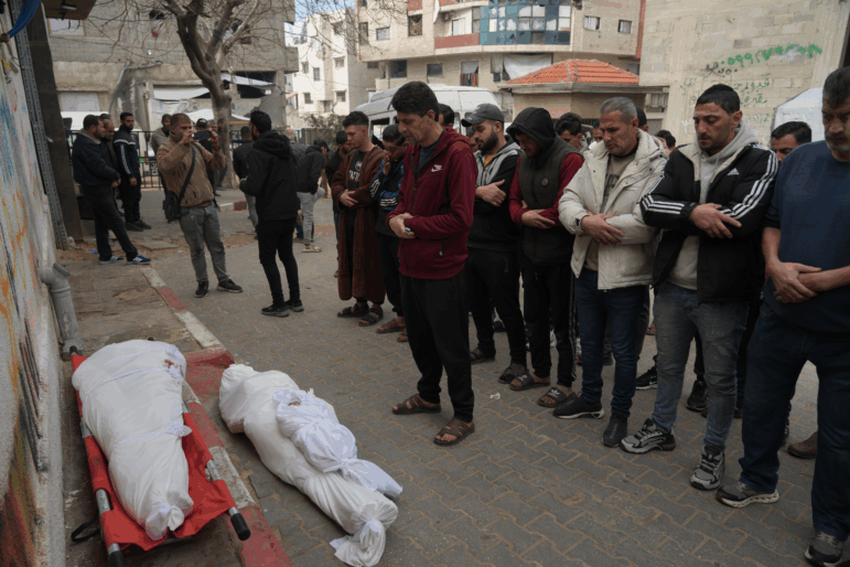 Palestinians mourn over the dead who were killed in an Israeli military strike, at Shifa Hospital in Gaza City, Wednesday, Feb. 4, 2026.