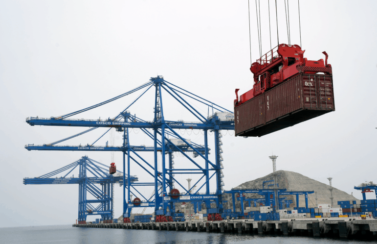 A container is lifted by a crane backdropped by the construction of the Chinese-funded port, in Chancay, Peru, Oct. 29, 2024.