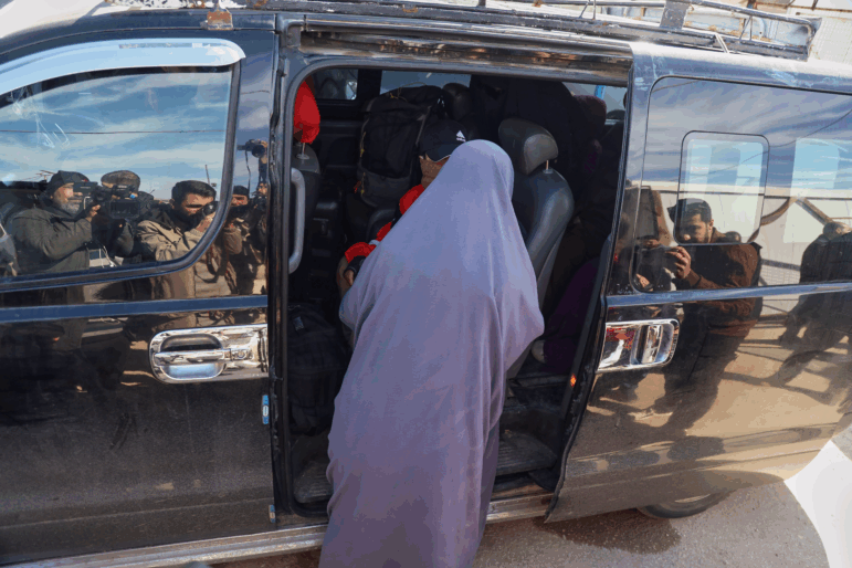 Family members of suspected Islamic State militants who are Australian nationals board a van heading to the airport in Damascus during the first repatriation operation of the year, at Roj Camp in eastern Syria, Monday, Feb. 16, 2026. Thirty-four Australian citizens from 11 families departed the camp.