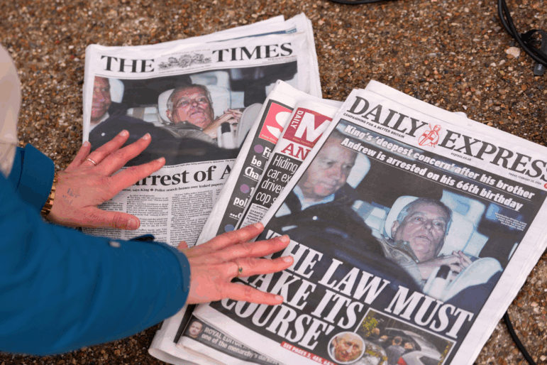 A journalist looks at Friday's newspaper front pages in London after Andrew Mountbatten-Windsor was arrested and held for hours by British police on suspicion of misconduct in public office related to his links to Jeffrey Epstein.