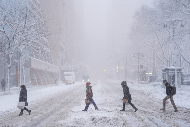 Pedestrians cross 42nd Street near Bryant Park on Monday during a snow storm in New York.