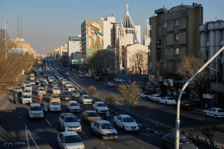Vehicles drive past the Saint Sarkis church and a painting of the late Iranian revolutionary founder Ayatollah Khomeini in downtown Tehran, Iran, Wednesday, Feb. 25, 2026.