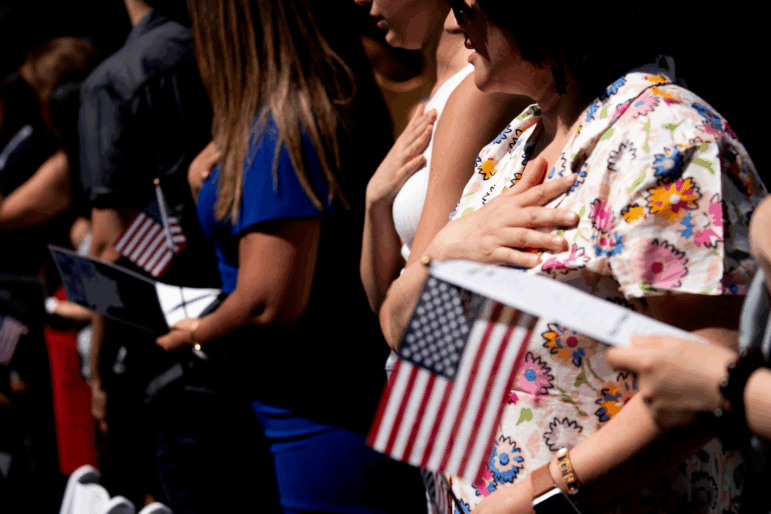 New U.S. citizens recite the Pledge of Allegiance during their naturalization ceremony in Mount Vernon, Va., in 2022.