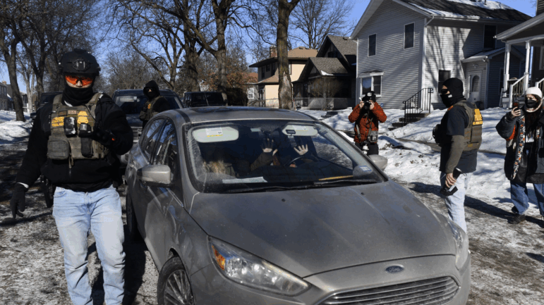 Federal immigration agents confront observers monitoring their activity from inside their cars while patrolling a neighborhood in Minneapolis on Jan. 29.