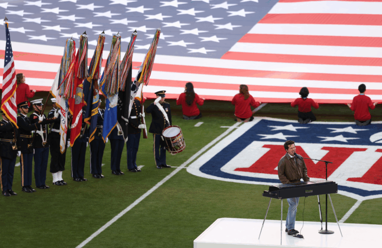 Standing in front of an electronic keyboard set up on a football field, singer Charlie Puth performs the national anthem ahead of this year's Super Bowl on February 8.