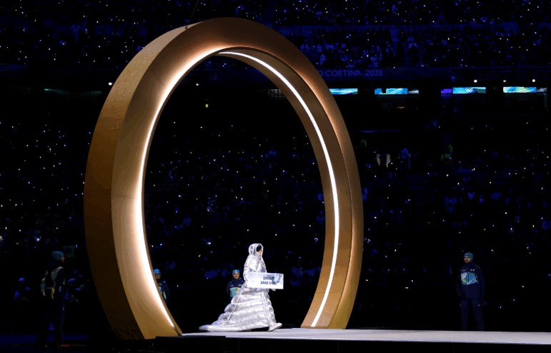 The women escorting each country's athletes during the Parade of Nations wore floor-length puffy coats and oversized sunglasses, in the dark of night.