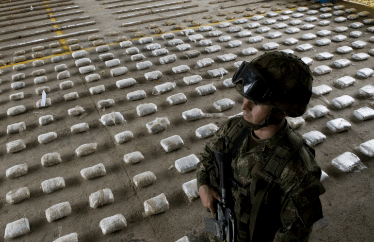 A Colombian Army soldier stands next to packages of seized cocaine during a press conference at a Military Base in Bahia Solano, department of Choco, Colombia, on March 14, 2015.