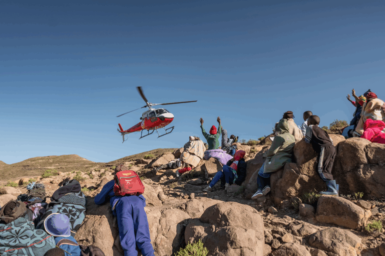 Residents of the isolated village of Mphooko wave as a team from the Lesotho Flying Doctor Service departs after a day treating patients in the village. Mphooko is inaccessible by road, and relies on the LFDS for basic medical care.