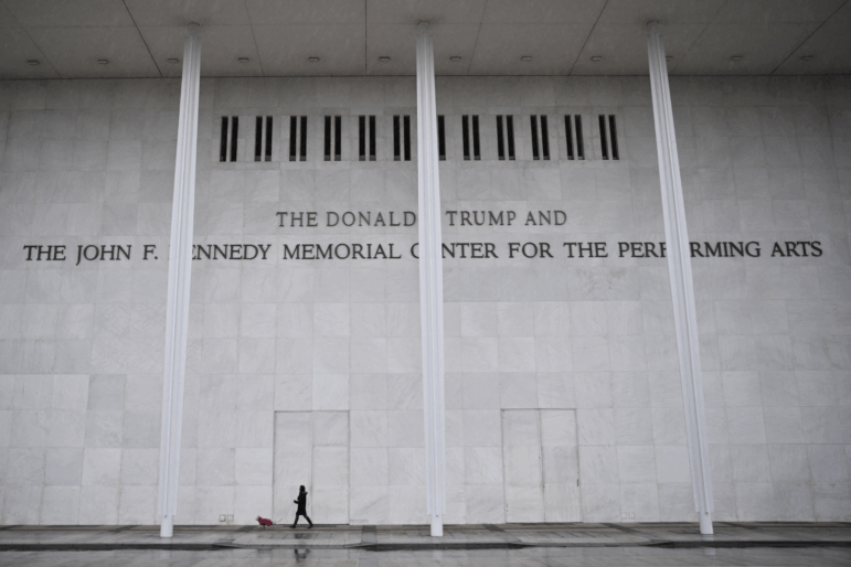 A person walks a dog in front of the Kennedy Center in Washington, D.C., on Jan. 10, 2026.